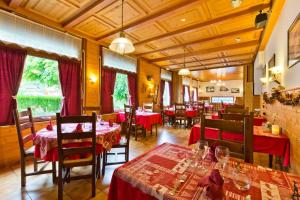 a restaurant with tables and chairs with red table cloth at Hôtel Le Bellevue in Thollon