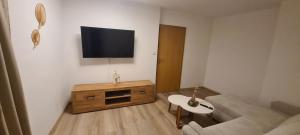 ein Wohnzimmer mit einer Couch und einem Fernseher an der Wand in der Unterkunft Merci Sweet Home in Niestetal
