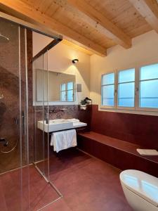 un bagno con doccia in vetro e lavandino di Boutique Hotel Bellevue a Interlaken Altre 94 foto