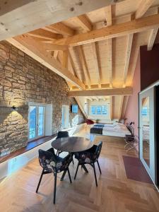 una stanza con tavolo, sedie e un muro in pietra di Boutique Hotel Bellevue a Interlaken