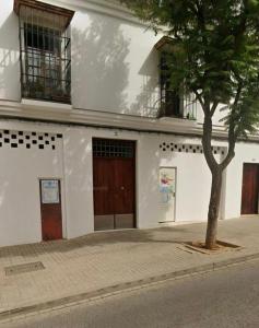 un edificio bianco con un albero di fronte di Apartamento Cerezo a Carmona Altre 3 foto