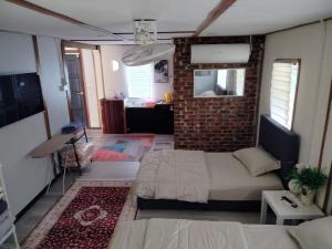 a bedroom with a bed and a brick wall at Tokpa Tokma's Haven in Jertih