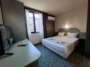 une chambre d'hôtel avec un lit et une télévision à écran plat dans l'établissement Korona Hotel, à Blagoevgrad