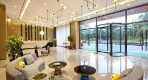 a lobby with chairs and a table and a piano at mango crystal hotel in Haikou