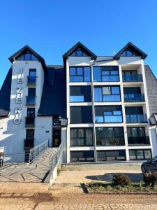 een groot wit gebouw met een trap ervoor bij Apartman Dan i Noć in Divčibare