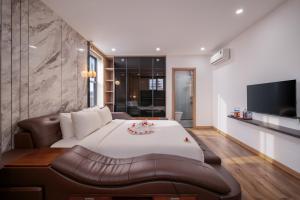 een slaapkamer met een groot wit bed en een bank bij KLY Hotel in Hue