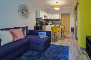 a living room with a blue couch and a kitchen at Ospitaria-Suite Sant'Anastasia in Verona