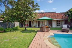 a backyard with a pool and a house with a table and chairs at Villa Pondok Terra in Yogyakarta