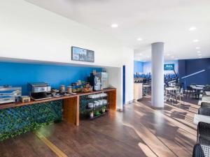 a restaurant with blue walls and a counter with food at ibis Budget Sydney Olympic Park in Sydney
