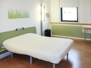 ein Krankenhauszimmer mit einem Bett und einem Fenster in der Unterkunft ibis budget Castelnaudary - A61 in Castelnaudary