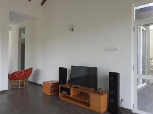 a living room with a flat screen tv and speakers at Sathmani in Pallekele Kadawidiya