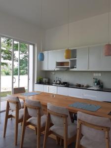a kitchen with a wooden table and some chairs at Sathmani in Pallekele Kadawidiya