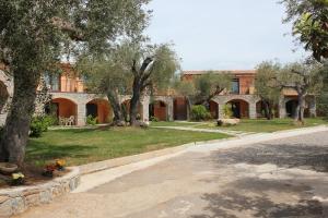 a courtyard with trees and a building in the background at Park Hotel Cilento in Marina di Camerota