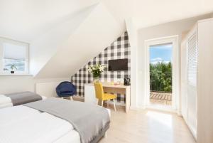 Schlafzimmer mit einem Bett, einem Schreibtisch und einem Fenster in der Unterkunft Villa Milla in Łeba