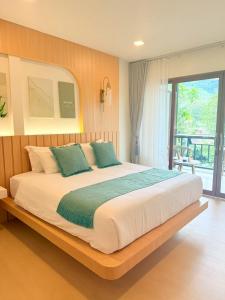 a bedroom with a large bed with blue pillows at Lanta Forest Resort & Villas in Ko Lanta Yai