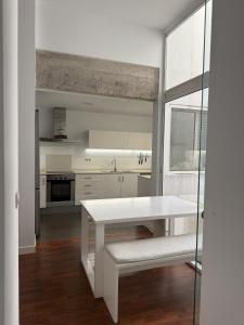 eine weiße Küche mit einem weißen Tisch und einem Fenster in der Unterkunft La COlectiva HOME in Xàtiva