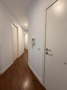 ein leeres Zimmer mit einer weißen Tür und Holzböden in der Unterkunft La COlectiva HOME in Xàtiva