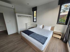 ein Schlafzimmer mit einem weißen Bett und einer blauen Decke darauf in der Unterkunft Na-Tub House in Ban Nua