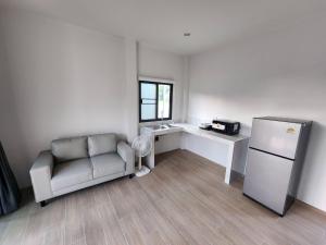 a living room with a couch and a refrigerator at Na-Tub House in Ban Nua