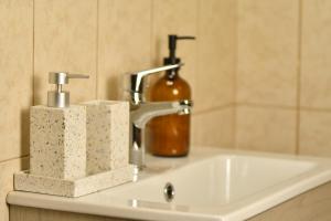 ein Waschbecken mit einem Seifenspender und einer Flasche in der Unterkunft Kostaras Comfort Stay in Dispilio + 15 Fotos
