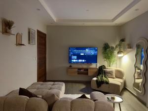 a living room with two couches and a flat screen tv at Sunkissed Haven - Coastal Escape in Flic-en-Flac