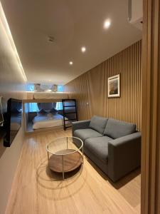 een woonkamer met een bank en een bed bij The Warehouse Chiang Mai in Chiang Mai