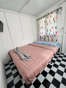 a bed in a room with a checkered floor at RT House Resort in Ban Phawon