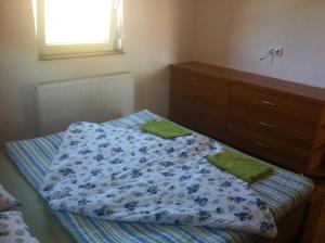 a bedroom with a bed with a dresser and green pillows at Bella Apartman in Balatonfüred