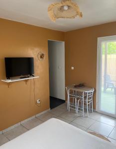 un soggiorno con tv e tavolo di lagon studio ermitage a Saint-Paul