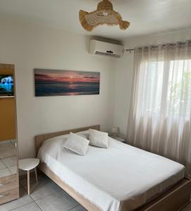 una camera da letto con un letto e una finestra di lagon studio ermitage a Saint-Paul