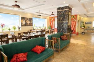 een restaurant met een groene bank en tafels en stoelen bij Adam Hotel Sa Pa in Sa Pa