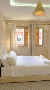 una camera da letto con un grande letto bianco con una finestra di Shams House a Imsouane Altre 13 foto