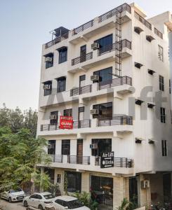 un edificio bianco con auto parcheggiate di fronte di Hotel Airlift at Delhi Airport a Nuova Delhi