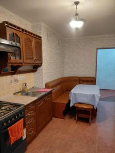 a kitchen with a sink and a table and a couch at 1 комната для 2х человек центр парк in Chişinău