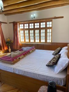 een groot bed met kussens in een slaapkamer bij Labrang Home Stay in Stak