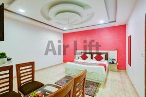 una camera da letto con un letto e una parete rossa di Hotel Airlift at Delhi Airport a Nuova Delhi Altre 56 foto