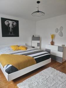 a bedroom with a bed with a black and yellow blanket at Welcome to Angèle 'Homes 2 in Niederbronn-les-Bains