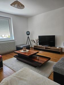 a living room with a coffee table and a flat screen tv at Welcome to Angèle 'Homes 2 in Niederbronn-les-Bains