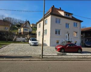 two cars parked in a parking lot in front of a house at Welcome to Angèle 'Homes 2 in Niederbronn-les-Bains