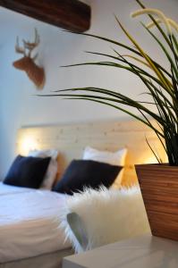 een slaapkamer met een bed met kussens en een plant op een tafel bij Hotel Beez in Maastricht