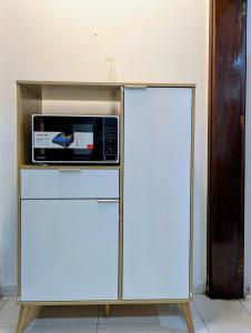 eine Mikrowelle auf einem Kühlschrank in der Unterkunft Cozy Comfort Studio Central Muscat in Muscat