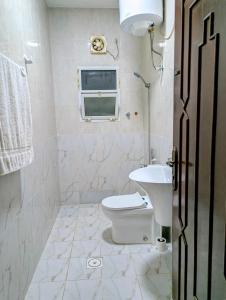 ein weißes Badezimmer mit Toilette und Waschbecken in der Unterkunft Cozy Comfort Studio Central Muscat in Muscat