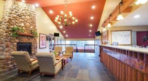 ein Restaurant mit einer Bar mit Stühlen und einem Kamin in der Unterkunft Ramada by Wyndham Monument in Monument