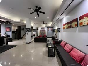a lobby with couches and a ceiling fan at Star House Patong in Patong Beach