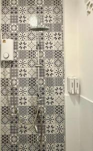 a shower in a bathroom with a black and white tiles at Chatuchak Haus in Bangkok +23 photos