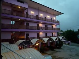 a building with a balcony with chairs in front of it at Erawan Place in Mae Sot