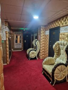 a room with two chairs and a red carpet at Faraon apartmani Beograd in Belgrade +2 photos