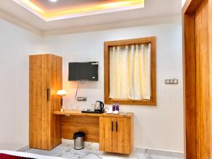a room with a desk and a tv on the wall at Hotel Betwa sarowar in Orchha +23 photos