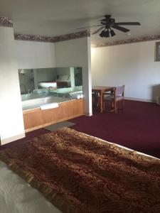 a bedroom with a bed and a table and a ceiling fan at Villa Inn Motel in Fort Atkinson