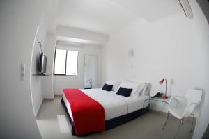 a white room with a bed and a television at Zalmedina Hotel in Cartagena de Indias